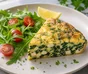 Skiver af spinat-feta-frittata serveret med rucola, cherrytomater og hakket kruspersille