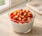 Chia- og yoghurtbudding i et glas med hakkede jordbær og ristede mandelflager